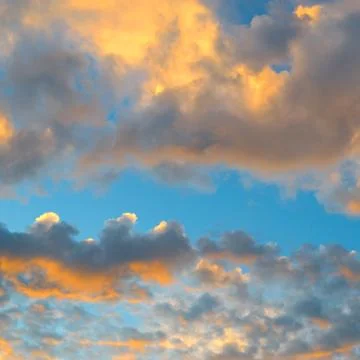 Scenic cloudscape of fluffy orange clouds glowing under warm evening sun li.. Photos
