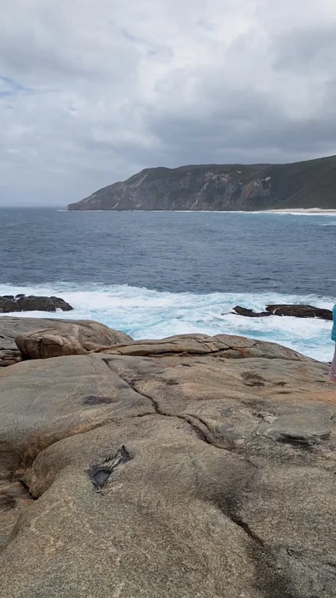 Scenic coastal view of large granite rocks and ocean waves with distant islan Video stock 335654071