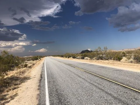 Scenic Desert Highway Under a Dramatic Sky at Golden Hour Stock Photos