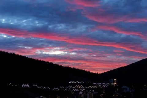 Scenic dramatic fiery cloudy sunset evening view over mountain resort village Stock-Fotos