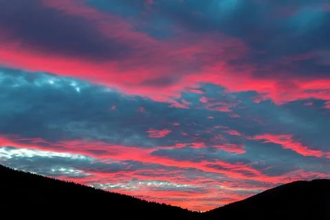 Scenic dramatic fiery cloudy sunset evening view over mountain resort village Foto stock