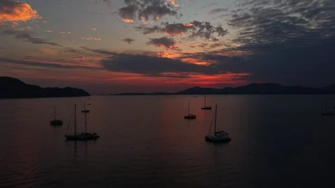 Scenic dramatic sunset over tropical bay with sailboats Видео 335613388