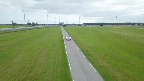 Scenic Drive through the Rolling Meadows: a Road on a Vast Green Field Stock Footage 246061426