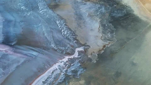 Scenic drone flight over dry pink lakebed with weird shape white dry salt Stock Footage 165454363