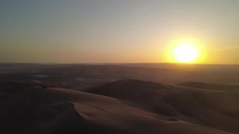 Scenic drone flight over a vast desert landscape at sunset with rolling san.. Stock Footage 327756224