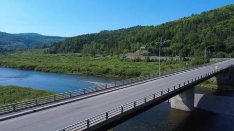 Scenic drone shot of a winding river beneath a concrete highway bridge Stock Footage 341679667