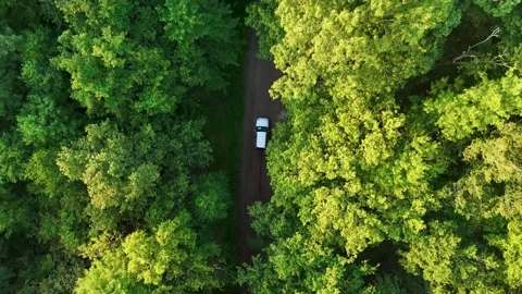 Scenic drone view of a silver car as it drives along a dirt road through... Stock Footage 341894278