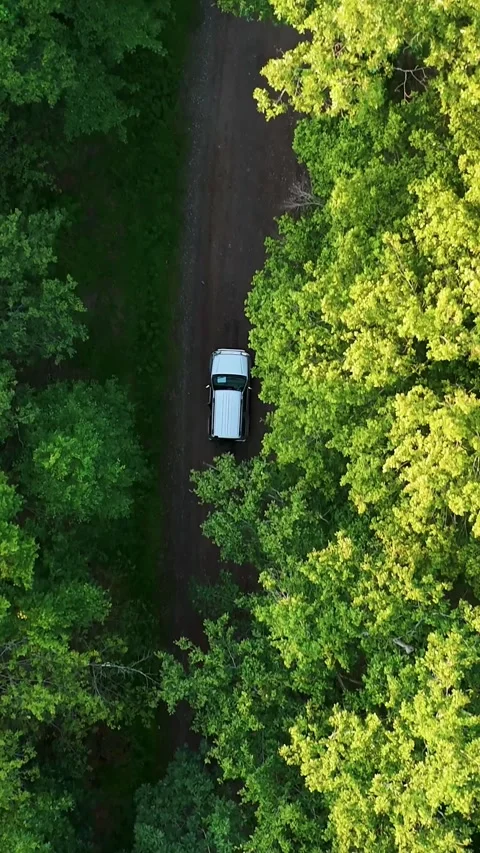 Scenic drone view of a silver car as it drives along a dirt road through... Vídeo Stock 344332652