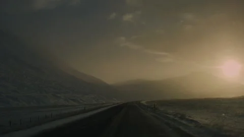 Scenic empty Icelandic road with strong winds pushing snow over icy surface Stock Footage 302997024