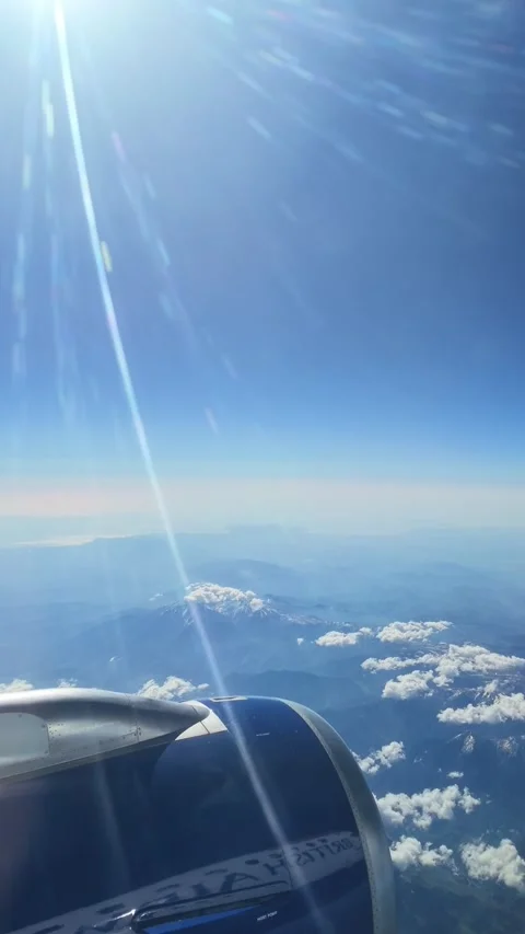 Scenic flight over puffs of cloud and mountains with bright sunbeams Stock Footage 337344759