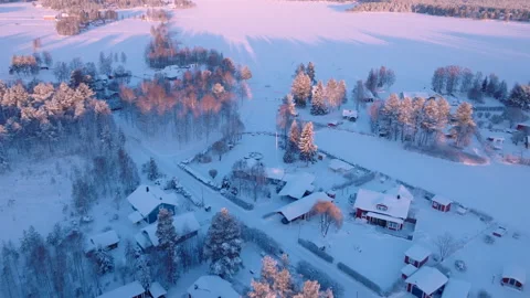 Scenic fly backward over small Swedish village, cold sunny winter day Stock Footage 228848957