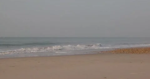 A scenic footage of a sandy beach with some crashing wave and majestic blue sky Stock Footage 162625378