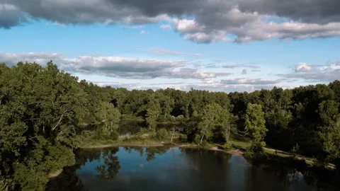 Scenic Forest Lake with Clear Reflections and Dramatic Clouds Stock Footage 276884123