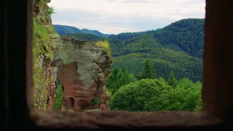 A scenic forested mountain view seen through a stone-framed window 스톡 동영상 309358688