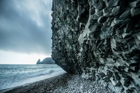 Scenic graphite rock at the seashore in cloudy weather Stock Photos