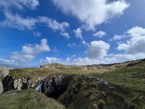 Scenic grassy cliffs under dramatic blue sky Stock-Fotos