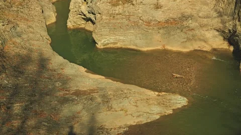 Scenic high-angle view of a calm river in a narrow gorge with textured rock Stock Footage 346471270