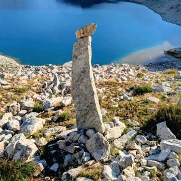 Scenic high angle view of stone cairn on rugged mountain terrain with glacial la Stock Photos