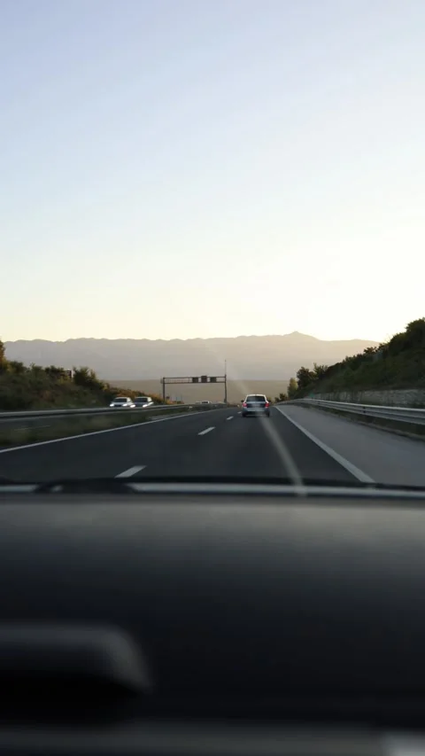 Scenic highway drive toward distant mountains in warm sunset light 스톡 동영상 341621986