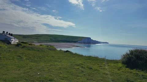 Scenic hilltop path overlooking ocean and coastal cliffs under clear summer sky Stock Footage 309768454
