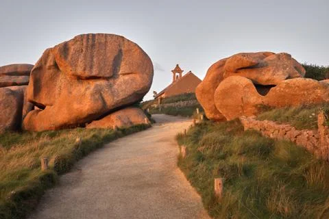 A scenic horizontal shot of a small path leading to a building through red ro Fotos de archivo