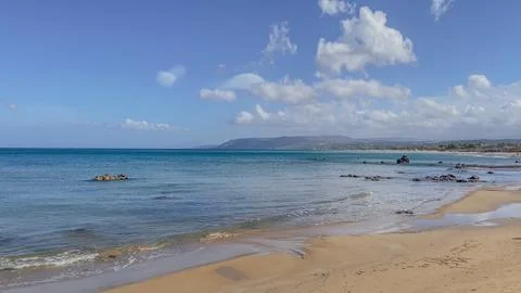 Scenic horizontal view of an empty sandy beach with gentle waves on the tur.. Stock Photos