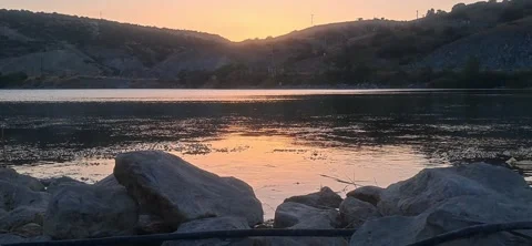 Scenic lake at sunset with rocks Video stock 343784413