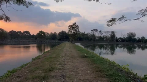 Scenic lakeside path during golden hour sunset 스톡 동영상 336452874