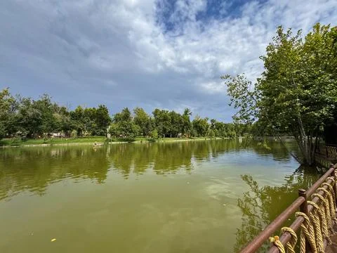 Scenic lakeside walkway with dramatic cloudy sky in a public park Фото
