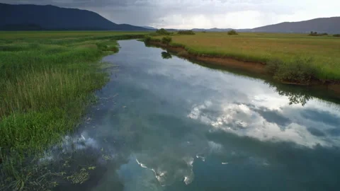 Scenic marsh landscape with river reflecting clouds Stock Footage 333204633