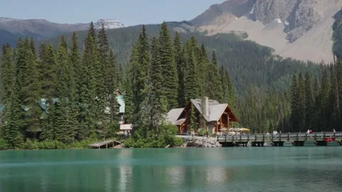 Scenic Mountain Lake with Rustic Cabin and Pine Forest Stock Footage 255968019