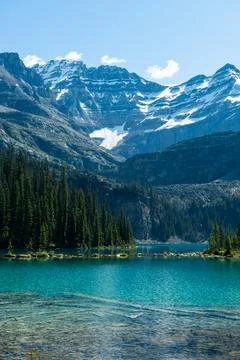 Scenic mountain landscape with turquoise lake and lush forest setting. Stock Photos