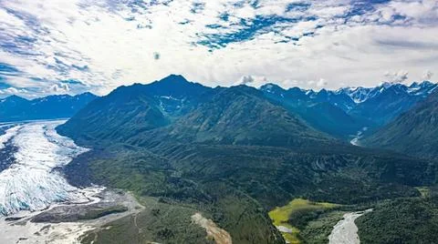 Scenic mountain range with river and cloudy sky Stock Photos