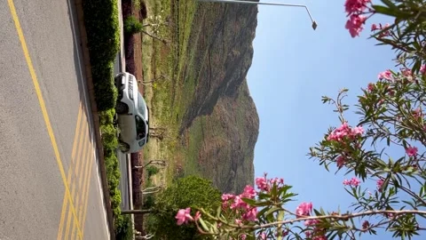 A scenic mountain view along the roadside invites adventure amidst lush greenery Stockbeeldmateriaal 283377262