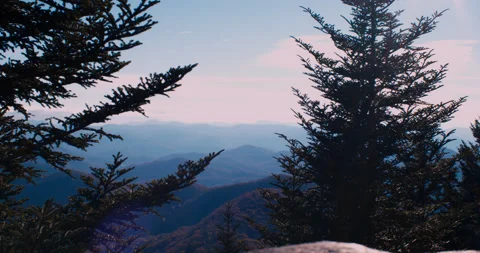 Scenic Mountain View with a large rock and trees in the foreground in 4k Stockbeeldmateriaal 144427687