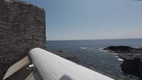 Scenic ocean horizon view over white stone lighthouse wall in ireland Stock Footage 340469948