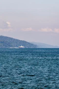 Scenic ocean view with distant forested island and calm waters at sunrise 写真素材