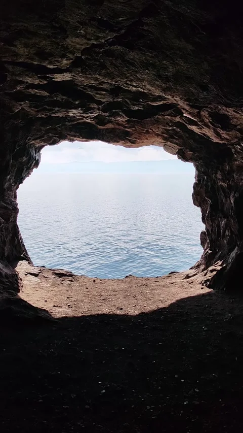 Scenic ocean view from inside dark rocky cave. Видео 335389644