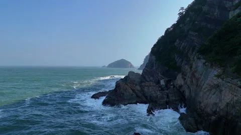 Scenic ocean waves crashing against rocky cliffs in busan 库存影片 341908761