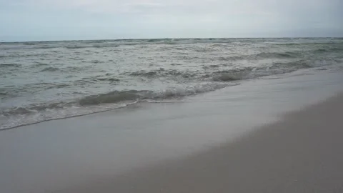 Scenic ocean waves rolling onto a pristine white sand beach Stock Footage 345689581