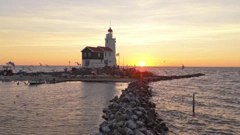 Scenic paard van marken lighthouse at sunset with flying seagulls Stock Footage 342813454