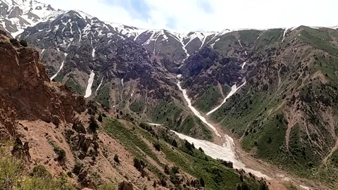 Scenic panning shot of snow-capped Chimgan mountains in Uzbekistan Stock Footage 335398946