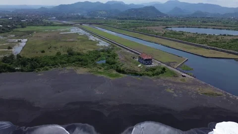 Scenic Panoramic Aerial View of Volcanic Black Sand Coast, River and Hills in Video stock 344991484