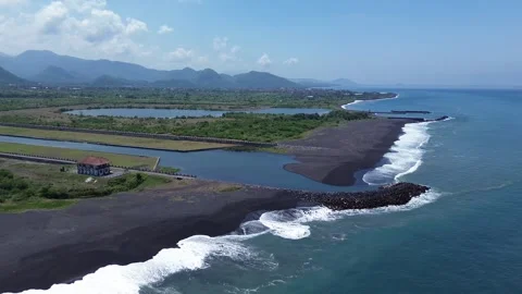 Scenic Panoramic Aerial View of Volcanic Black Sand Coast, River and Hills in Видео 344991878