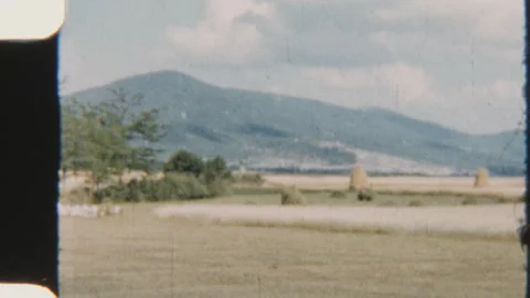 Scenic Patchwork Fields With Haystacks And Mountain Backdrop Stock Footage 320879355