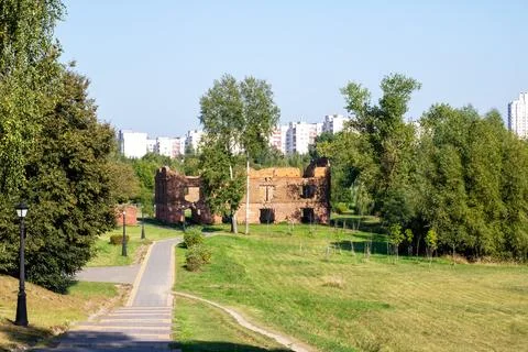 A scenic path through a park with trees and buildings behind Stock Photos
