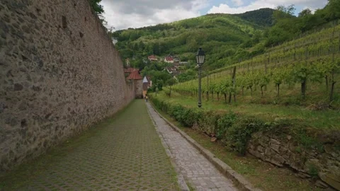 A scenic paved path alongside an ancient stone fortress wall Видео 336911329