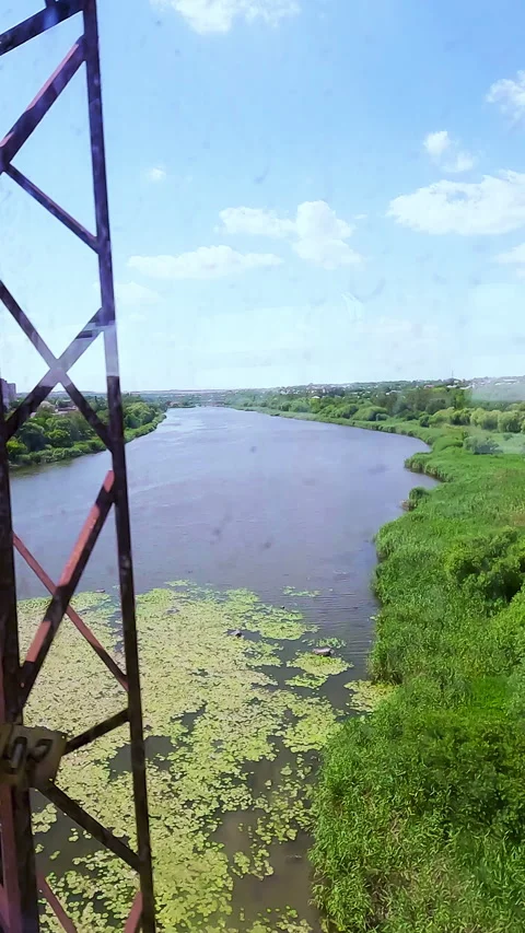 Scenic point of view look through a passenger train window at a wide river with Stock Footage 338398342