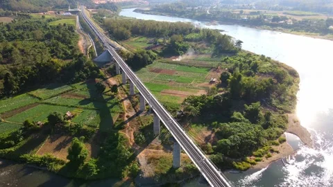 Scenic Railway Bridge Over River and Mountains at Sunset in Rural Landscape Stock Footage 343919224