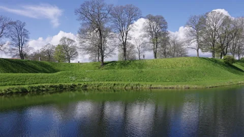 Scenic Reflections of Clouds and Trees on Calm Water Stock Footage 309454779